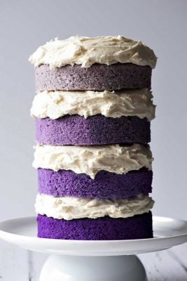 four layers of purple cake with buttercream frosting in between. Sides are not frotsted