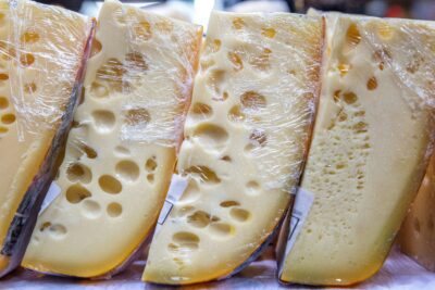 blocks of swiss cheese, partially covered in plastic wrap. Photo by Wagner Vilas on Unsplash