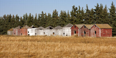 old red, white, and gray silos in a field