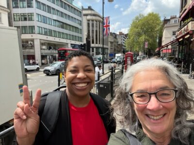 Regine Gilbert and Lainey Feingold smiling on a London street corner