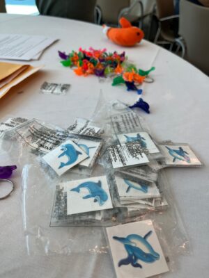 temporary dolphin tattoos on a table with dolphin keychains in the background